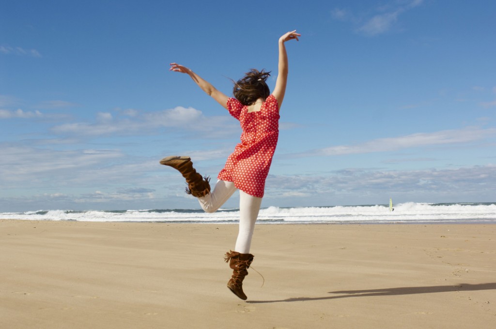 Jeune fille qui danse sur la plage en hiver. Impression de bien-être.