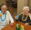 Un couple en maison de retraite boit une boisson vitaminée.